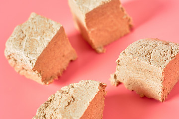 Pieces of sunflower halva on pink background. Turkish sweets