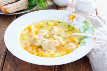 Homemade chicken soup with dumplings in a white plate, selective focus