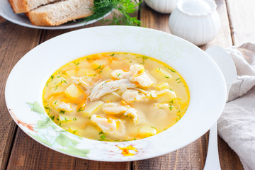 Homemade chicken soup with dumplings in a white plate, selective focus