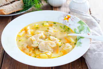 Homemade chicken soup with dumplings in a white plate, selective focus