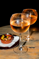 A glass of cold chilled rose wine served at a restaurant table. Water droplets are dripping