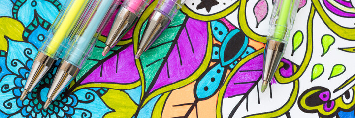 Adult coloring book, stress relieving trend. Art therapy, mental health, creativity and mindfulness concept. Flat lay web banner, panoramic close up shot.