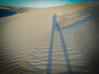 Amazing sunset in Jericoacoara beach in Ceara, Brazil, with shadow of a person in the sand. Famosu...
