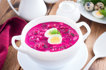Traditional cold summer beetroot soup with vegetables in a white bowl, selective focus