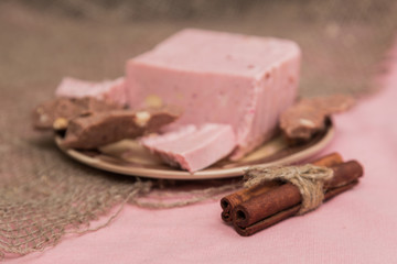 Tiles of a broken exquisite hand-made chocolate with dried and fresh berries, nuts. selective focus