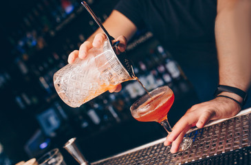 Bartender pouring using strainer White healthy Cocktail drink on a bar counter . Professional view . Trendy stylish alcoholic drink .  Design people and luxury concept service barman in nightclub