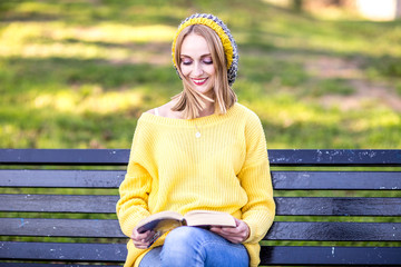 young woman sitting in the park reading