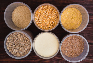 Raw porridge, food supplies in the kitchen. A variety of cereals in the food containers.