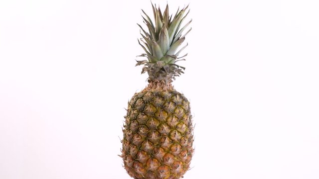 Whole Pineapple Rotates On A White Background