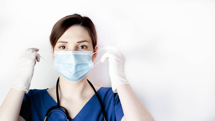 Girl doctor takes off a medical mask on a white background  A