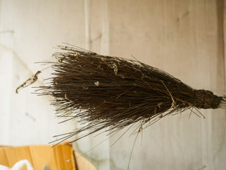 Old cobweb broom stored under the house roof.