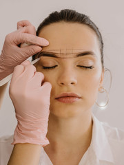 Mikrobleyding eyebrows workflow in a beauty salon. Very beautiful model