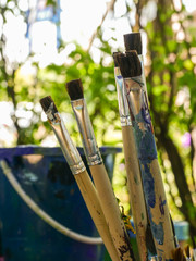 Old paint brushes that have been used in a variety of sizes