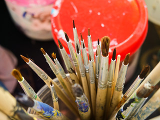 Old paint brushes that have been used in a variety of sizes