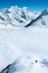 Group of climbers reach the summit of mountain peak  climbs a snowy ridge and enjoying the landscape view.