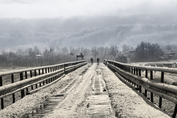 Two men walking across a snowy iron bridge. River Inguri, Samegrelo region, Georgia, photo 4/4.