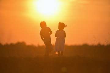 Fototapeta na wymiar happy child boy and girl overall playing on sunny field, summer outdoor lifestyle, cozy mood