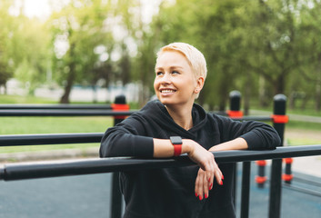 Attractive fit young woman in sport wear rest on street workout area. Healthy lifestyle in the city