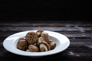 Shiitake mushrooms on the wooden background.