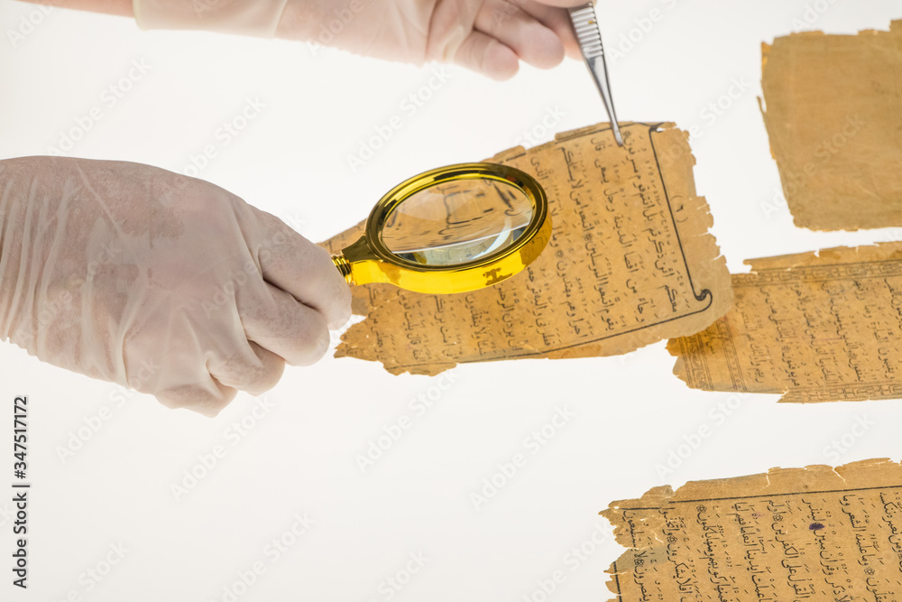 Sticker a researcher studies arabic writing from the koran using a magnifying glass and a table with a light