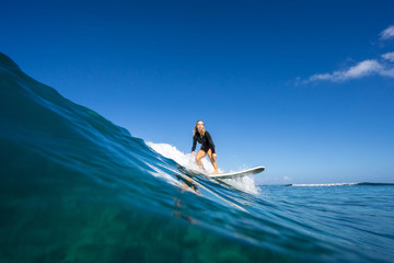 young beautiful blonde girl surf on the big waves in the open ocean. Mauritius Island