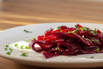 beetroot in a white plate on the wooden table