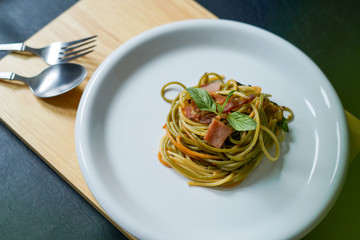 Plate of delicious tasty homemade spaghetti bolognaise or bolognese with savory minced beef ham and basil, overhead or top view
