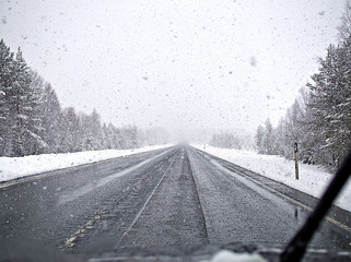Driving in very slippery and dangerous conditions on frozen and snow covered road in Finnish winter.