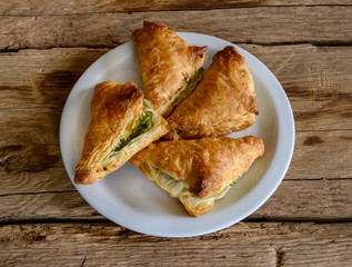Pies filo pastry with chicken and spinach  close-up on the wood deck.
