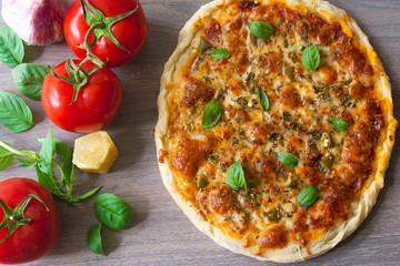 Homemade vegetarian margarita pizza with Parmesan and mozzarella cheese and traditional tomato...