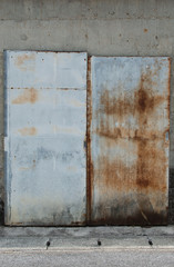 壁に貼り付けた古びた鉄板の扉