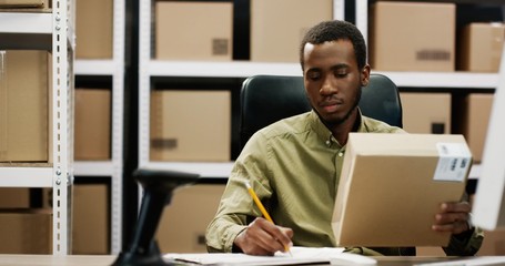 Postman registering carton box and writing data and information in document. Delivery service...