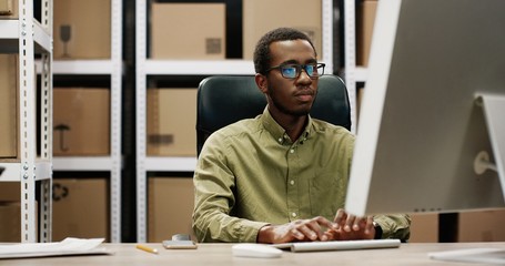 Delivery service concept. African american man using computer.
