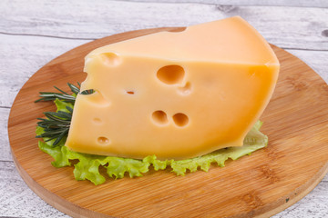 Maasdam cheese  in the board served salad leaves