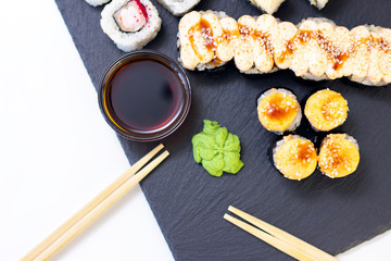 Set of rolls, sauce and wooden sticks on a stone black table. Top view with copy space.