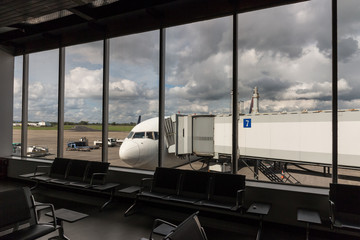Looking out at Commercial aircraft through empty airport waiting lounge