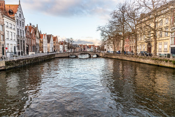 Buildings around channels in Bruges at sunset