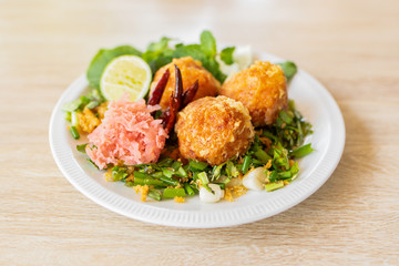 Fermented Pork and Crisp Rice Salad or Yam Naem Khao Tod Recipe,Thai food concept.Top view and wooden background.