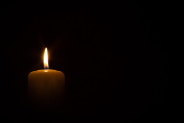 burning candle isolated on black. backgrounds and textures