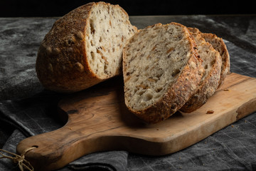 Bread fresh home baking on a wooden board. Black background