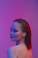 A beautiful young girl in wireless headphones listens to song with a good mood. bright colorful music poster.