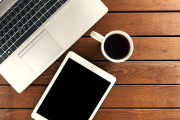 set of modern computer devices - laptop, tablet, notebook and  cup of tea