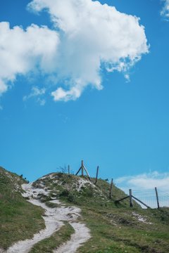 Pathway On Grassy Hill Against Blue Sky