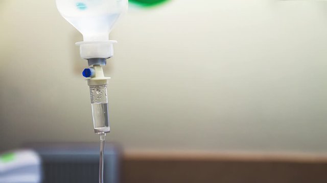 Cinemagraph of a fluid intravenous saline drip in a hospital room. Close up on Set IV fluid intravenous drop saline on a white background. Loop, selective focus, and copy space.