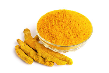 Turmeric powder in glass bowl with dry roots isolated on white background.