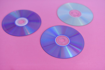 Selective focus on compact disc isolated against pink background