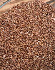Buckwheat in a glass bowl. Raw buckwheat porridge.