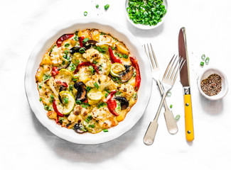 Baked vegetables frittata - delicious appetizer, tapas, snack, breakfast on a light background, top view