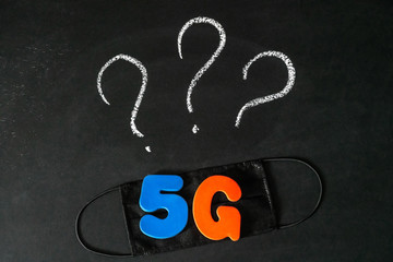 Symbol of coronavirus and 5g network next to a medical mask. The effect of 5g networks on coronavirus