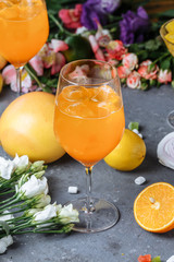 Aperol spritz cocktail in a large glass, summer Italian low alcohol cold drink. On a decorative background, with a strawberry, orange and decor